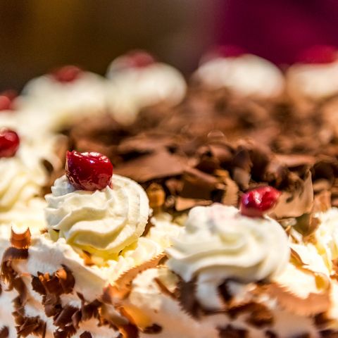 Zum Schluss wird die fertige Torte beim Schwarzwälder Kirschtorten Kurs in Baiersbronn mit Kirschen verziert.