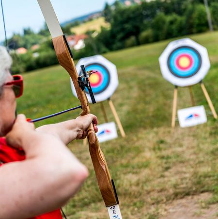 Eine Teilnehmerin beim Zielen mit Pfeil und Bogen beim Schnupperkurs im Bogenschießen bei Sport Frey.