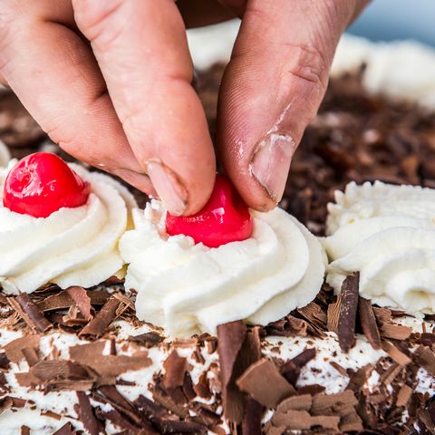 Beim Schwarzwälder Kirschtorten Seminar in Freudenstadt wird die fertige Torte zum Schluss mit Kirschen verziert. 