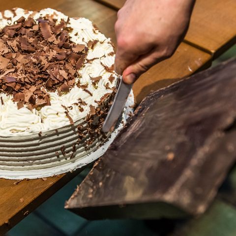 Beim Schwarzwälder Kirschtorten Kurs in Baiersbronn zeigt der Konditormeister, wie die Schokolade geschabt und die Torte damit verziert wird.