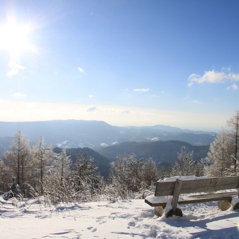 Verschneite Bank auf der Schwarzwaldhochstraße mit tollem Ausblick über den Schwarzwald.