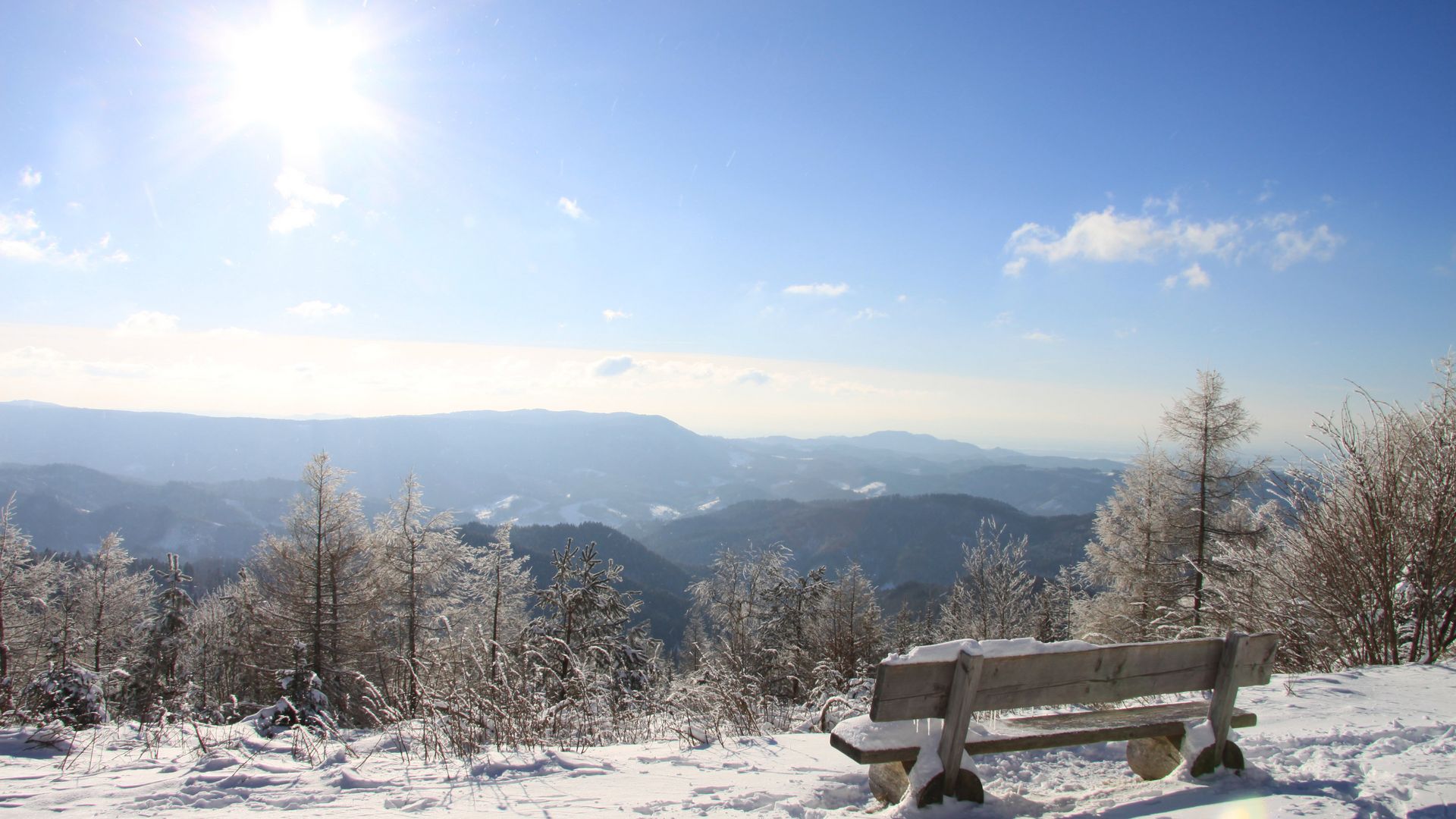 Verschneite Bank auf der Schwarzwaldhochstraße mit tollem Ausblick über den Schwarzwald.