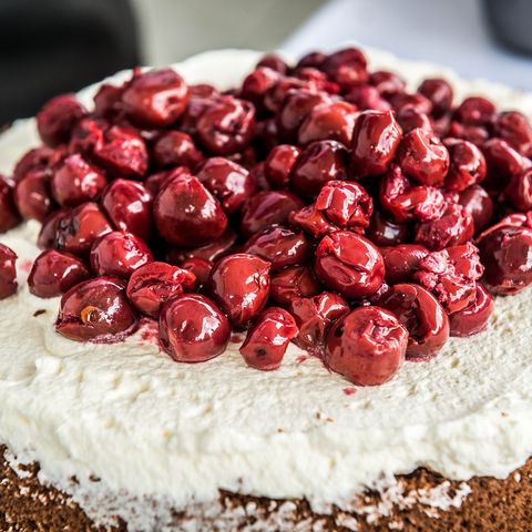 Beim Schwarzwälder Kirschtorten Seminar in Freudenstadt wird bei der Zubereitung der Torte auf einer Schicht Sahne und Kirschen verteilt.