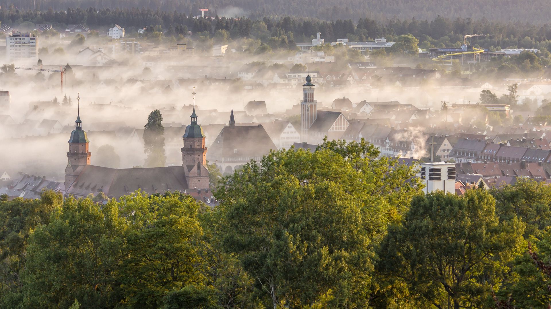 Sommerlicher Blick auf Freudenstadt mit seinem Marktplatz im Morgennebel vom Friedrichsturm auf dem Kienberg. 